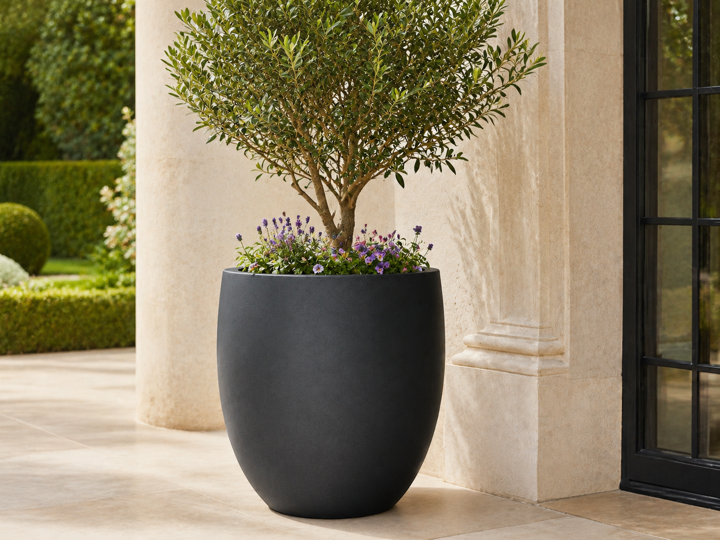 Smooth black round egg fiberclay planters on stone patio