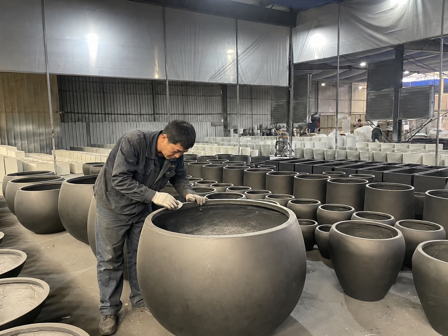 Worker making up large outdoor fiberclay flowerpot